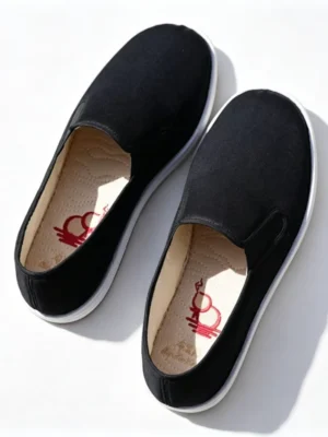 LUNO LN-M4007 men's cloth shoe - top-down view displaying a pair of black slip-on shoes with a clean white sole edge and beige insole featuring red branding; the minimalist design emphasizes comfort, breathability, and traditional craftsmanship for everyday wear.