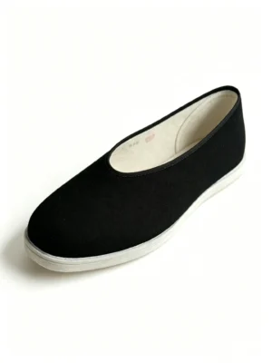 Angled side view of LUNO LN-M3042 men's round toe cloth shoes - black fabric upper with white rubber sole and visible hand-stitched seam along the heel
