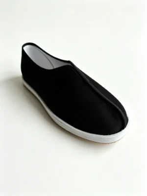 LUNO LN-M5025 traditional Chinese cloth shoes side view - featuring a sleek black canvas upper with elastic side panels for easy slip-on wear, and a white layered rubber sole; the interior reveals a quilted insole with embroidered mugwort leaves and red "Beijing Cloth Shoes" characters, emphasizing herbal comfort and cultural craftsmanship.